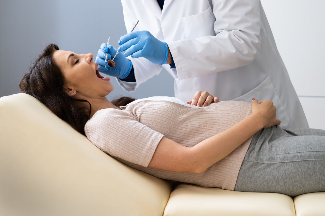 Pregnant woman receiving a safe dental exam from a dentist during pregnancy, highlighting the importance of prenatal oral health care
